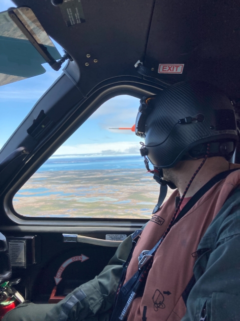 person in helmet looking out an airplane window