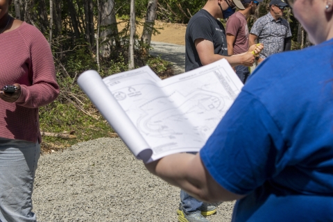 A project manager with the Alaska Fish and Game looks at blueprints of a parking lot expansion 