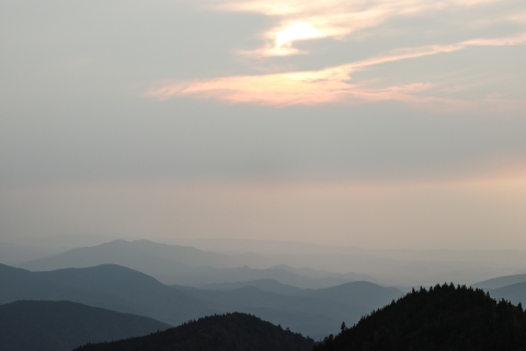 Rolling mountains beneath a cloudy, dimmed sky