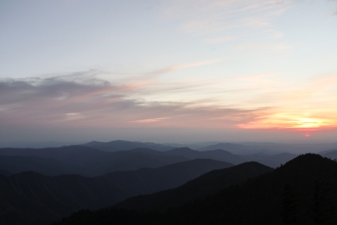Rolling mountains with a setting sun in the background