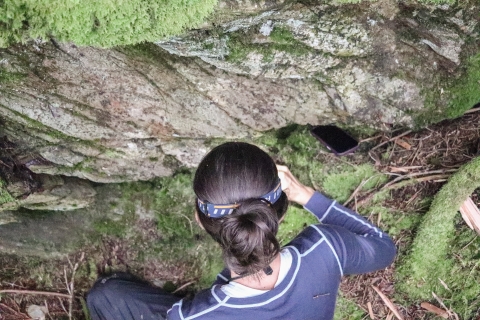 Woman bending over examining a moss patch