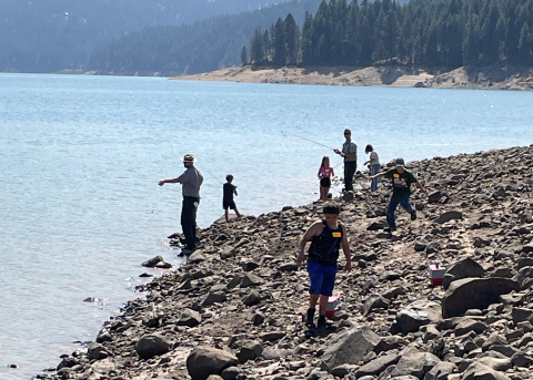 Children fishing at a reservoir on a summer day