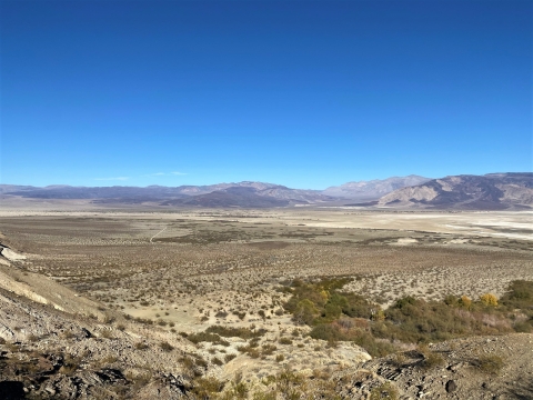 Aerial view of the arid, shrubby landscape with mountains in the background