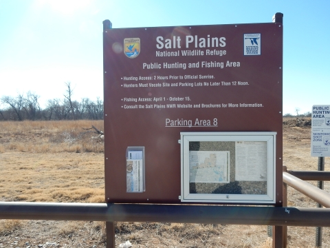 Large brown public hunting and fishing area sign at Salt Plains National Wildlife Refuge.