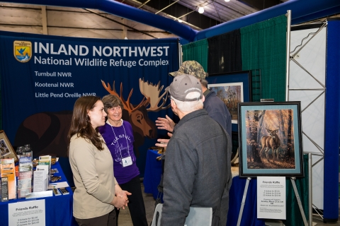 Event participants speak with staff from Friends and FWS
