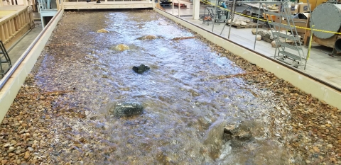 A structure of clustered pebbles and rocks with water running over them