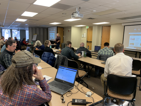 A classroom with individuals listening to a lecturer 