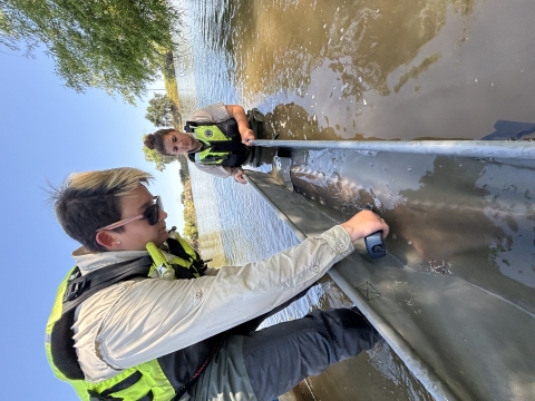 Two people with a large fish in a body of water