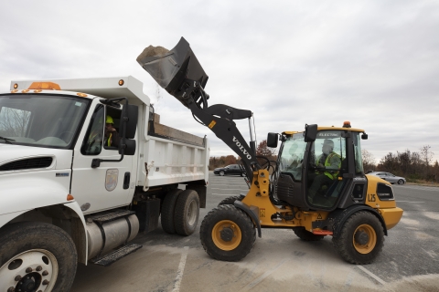 Front-end loader dumping dirt in a truck