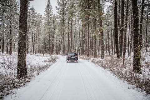 A car drives on a snow covered road