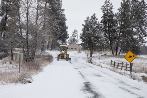 A dozer plowing snow from a refuge road