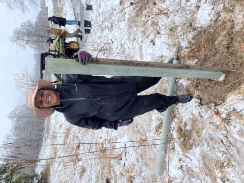 Volunteer poses with tree planting at Cherry Valley National Wildlife Refuge