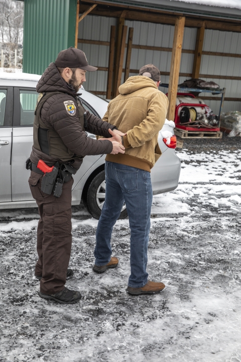 Refuge officer demonstrating how to handcuff someone