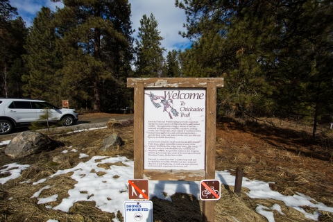 An interpretive sign denotes the entrance to a small trail