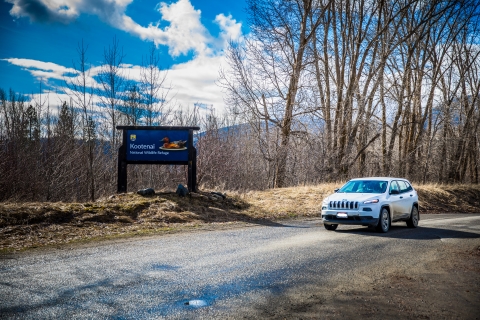 A blue entrance sign marks the border of a national wildlife refuge