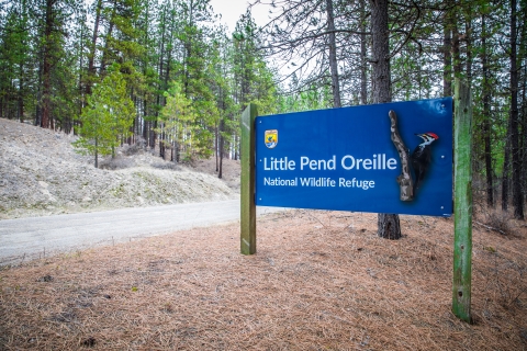 A blue entrance sign at a wildlife refuge