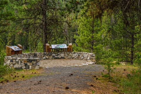 A stone circular overlook with two interpretive signs