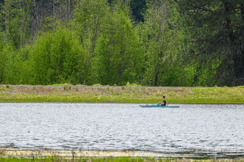 A kayaker fishes while floating