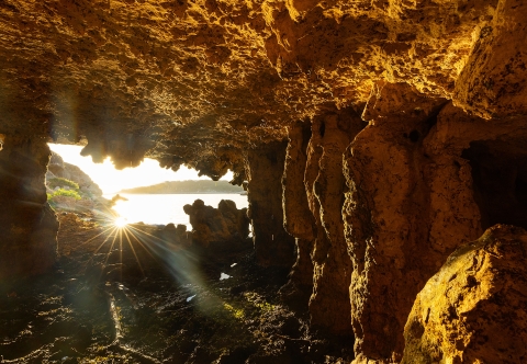 inside cave looking out on sunny lake