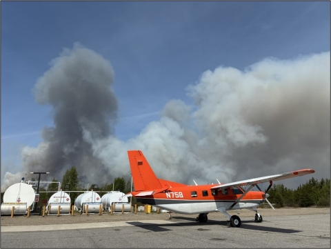 smoke fills the air behind an airplane on the ground 