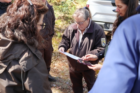 Group of people with one studying a paper in their hand.