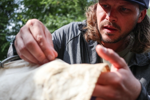 Person pulling something off a stretch of canvas
