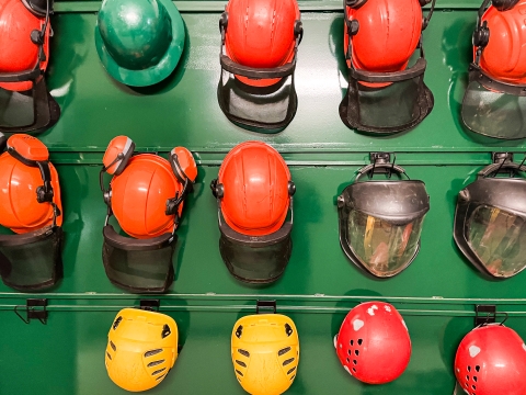 Numerous helmets stored on a wall
