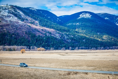 A car drives along riverside road at Kootenai NWR