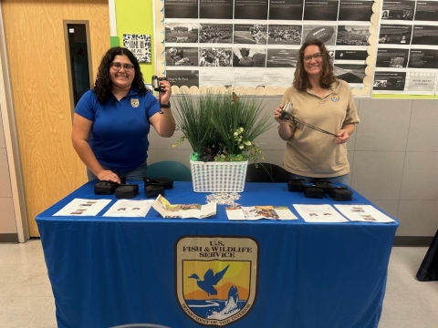 Two U.S. Fish and Wildlife Service field biologists standing behind a table at the Corpus Christi School of Science and Technology’s Gifted and Talented Spring Festival 