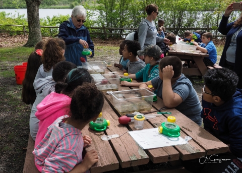 Volunteer instructs a group of school children