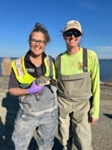 two biologists, one holding a duck 