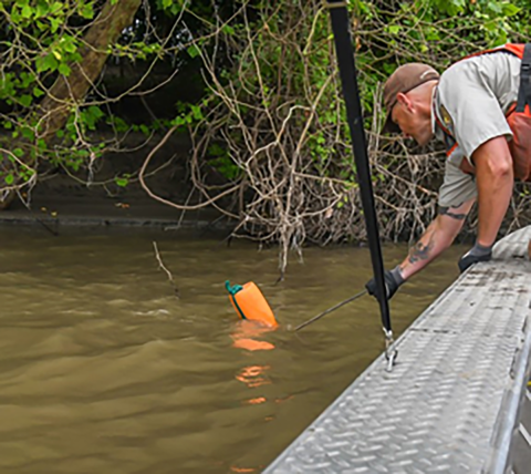 Retrieving a net by using a gaff to grab the float.