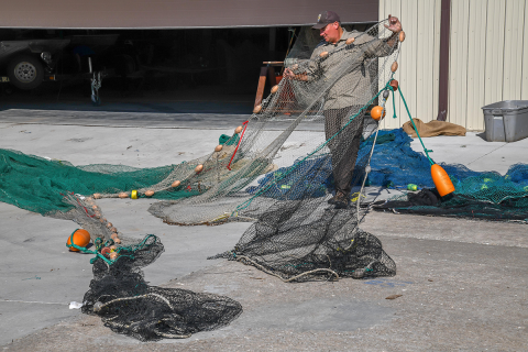 An instructor is holding up one wing of a surface trawl.