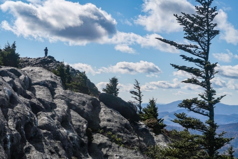 Person standing atop a rocky peak