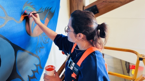person painting mural on wall