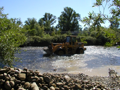 Loader pouring gravel into the Merced River