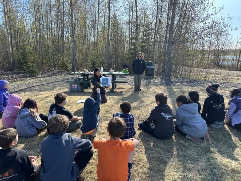 What kind of eater are you? Briefly sitting to talk about predators and prey dynamics, USFWS biologists and Fairbanks 4th graders get ready to run and play at Outdoor Days