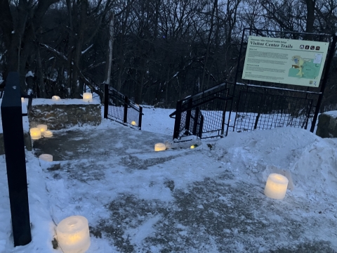 Stairs covered in snow with illuminating ice fixtures with candles inside