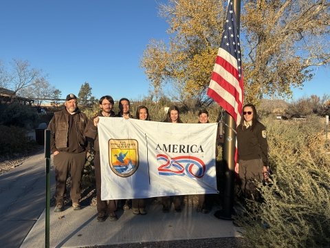 FWS staffers hold America 250-FWs flag as US flag flies