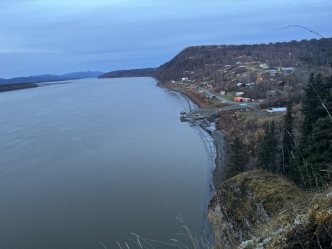 Landscape picture of a town next to a large body of water with an overcast sky
