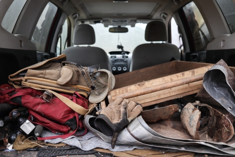 Variety of field equipment piled in the back of a vehicle.