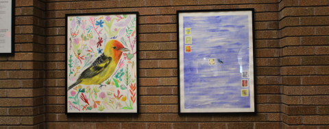 Two framed art pieces on a brick wall