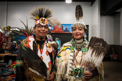 Tribal members pose for a photo with regalia made from bald and golden eagle feathers at Denver March Powwow.