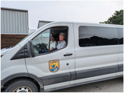 Image of two females in a USFWS van smiling at the viewer.