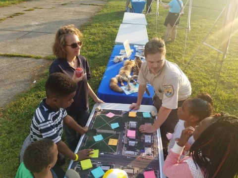 Refuge employee talks with people of various ages.