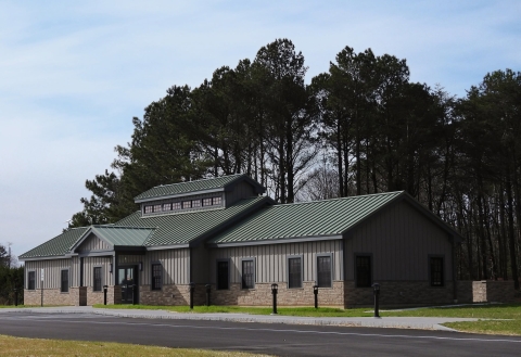 Modern building against forested background.