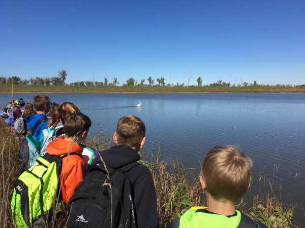 A class of students look out at a body of water.