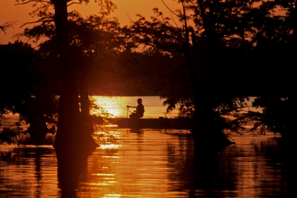 An image of a person on a boat at sunset.