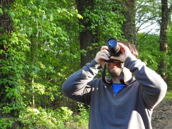 An image of someone taking a picture in the woods.