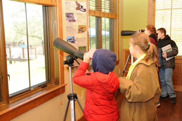 An image of visitors watching wildlife through the windows of the visitor center..